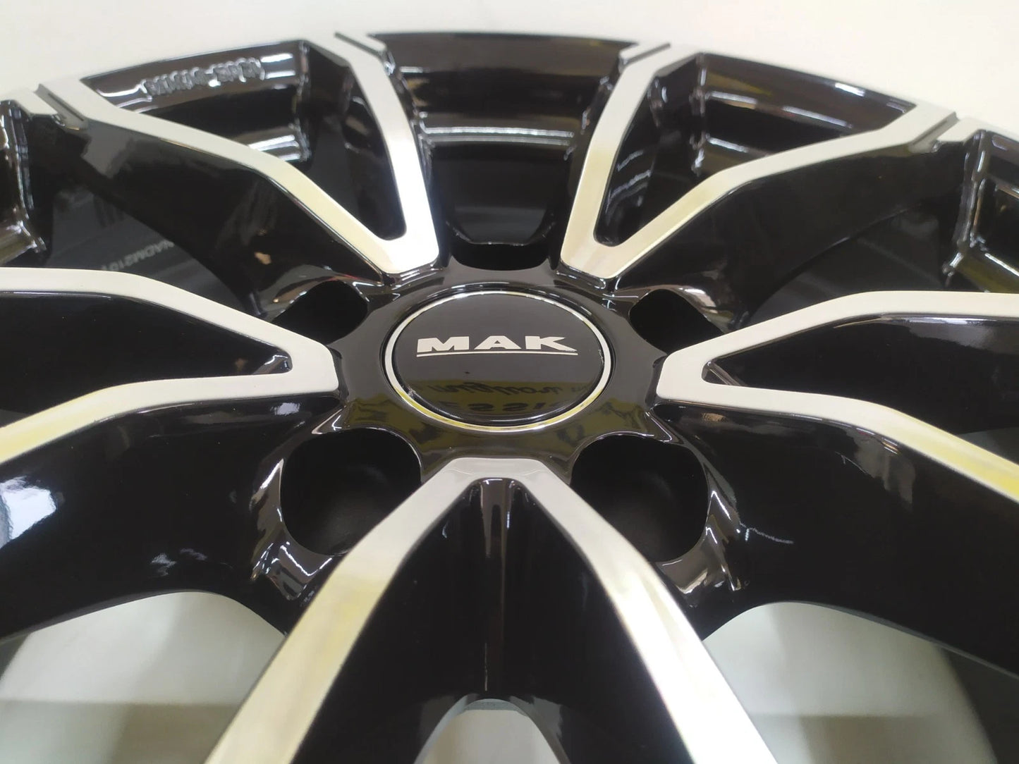 Primo piano cerchio MAK nero lucido con superfici diamantate e logo centrale cerchi in lega MAK 17 pollici Skoda