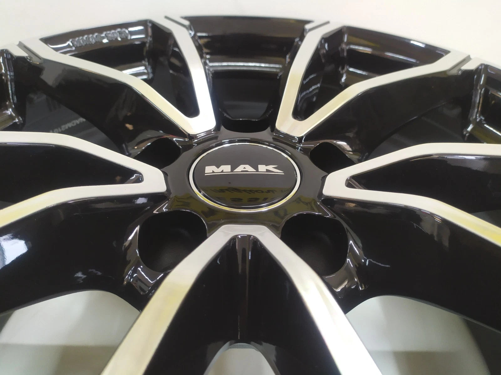 Primo piano cerchio MAK nero lucido con superfici diamantate e logo centrale cerchi in lega MAK 17 pollici Skoda
